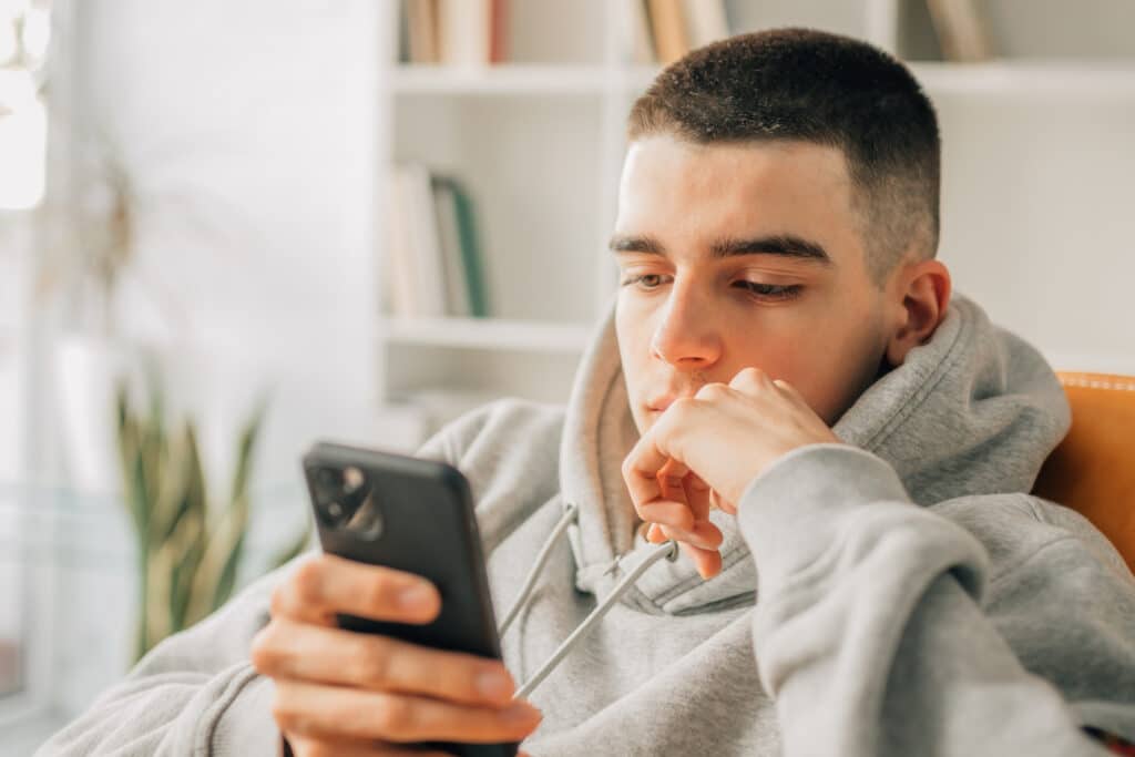 teen boy looking at his cell phone