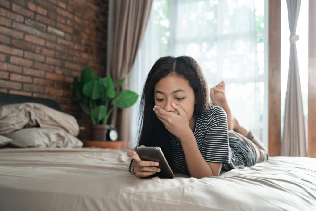 teen girl feeling shocked while looking at her phone