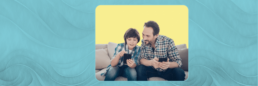 dad and son looking at cell phones together on a couch