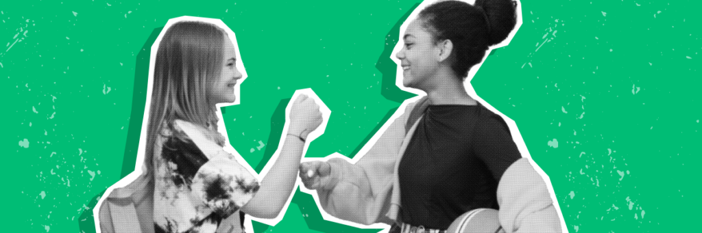 two teen girls giving each other knuckles